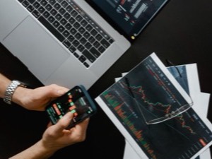 Trading desk with laptop, phone and price charts
